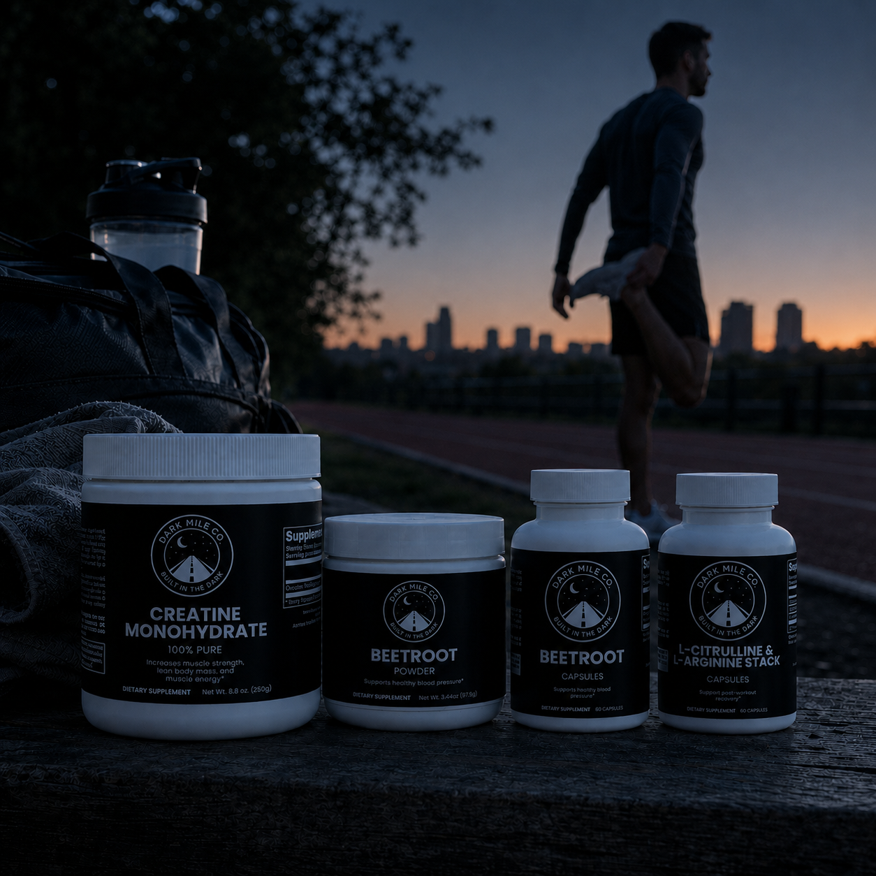 Dark Mile Co. creatine, beetroot, and L-citrulline supplement products on a wooden surface at early dawn, with a runner stretching near a track and city skyline.